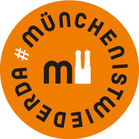 Das Bild zeigt ein orangefarbenes Logo mit der Aufschrift #MünchenIstWiederDa und einer stilisierten Darstellung der Frauenkirche.